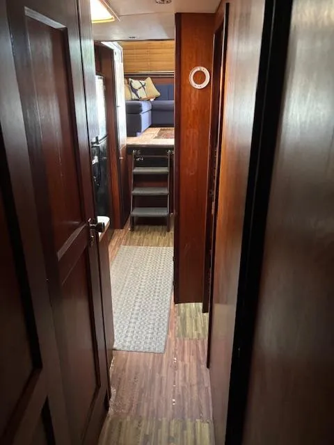 Slide: The Image of Interior hallway of a 1976 Hatteras 46 yacht with wooden paneling and carpeted floor. - 25