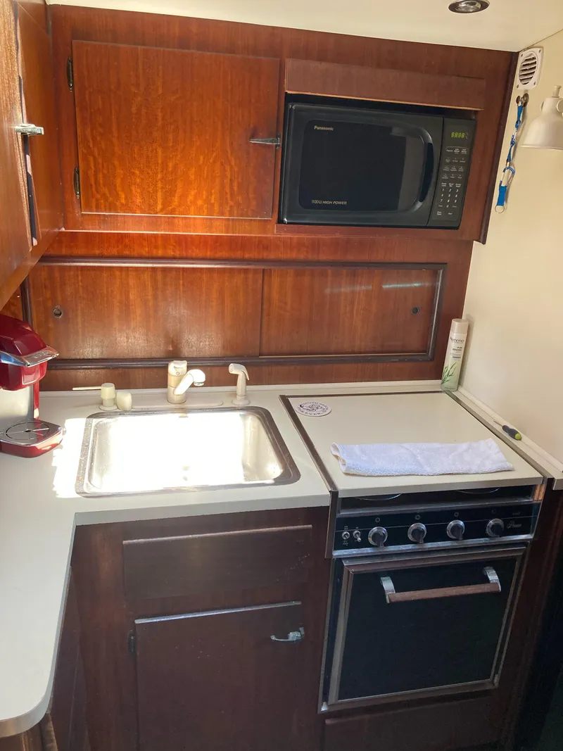 Slide: The Image of 1976 Hatteras 46 yacht kitchen with sink, stove, and microwave. - 28