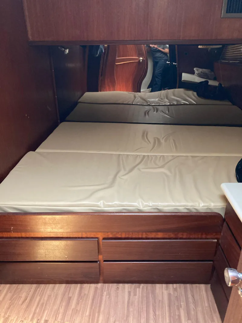 Slide: The Image of 1976 Hatteras 46 interior cabin with twin beds and wooden drawers. - 33