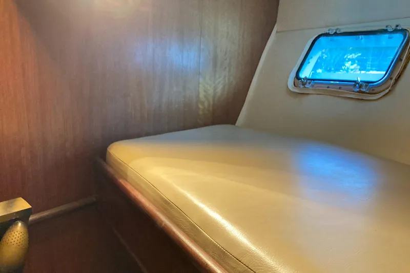 Slide: The Image of Cozy cabin interior of 1976 Hatteras 46 yacht with wooden walls and small window. - 35