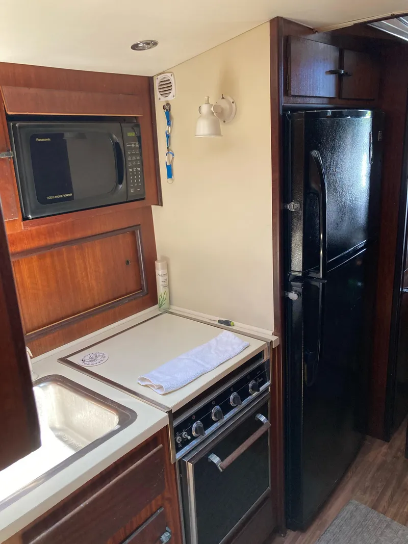 Slide: The Image of 1976 Hatteras 46 yacht kitchen with stove, microwave, and refrigerator. - 37