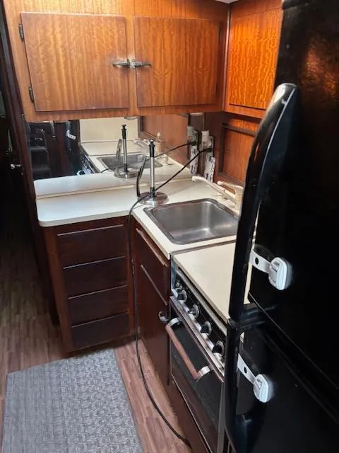 Slide: The Image of 1976 Hatteras 46 yacht kitchen with wood cabinets, sink, stove, and refrigerator. - 38
