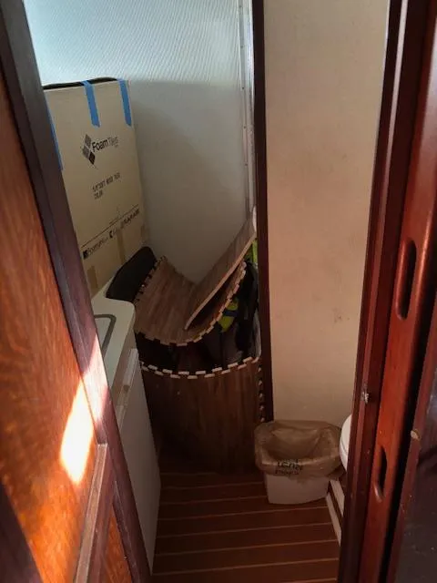 Slide: The Image of 1976 Hatteras 46 interior with storage items and wooden flooring. - 46