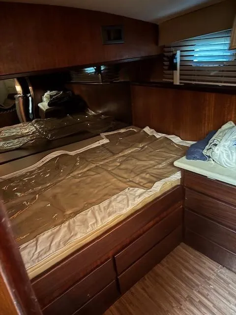 Slide: The Image of 1976 Hatteras 46 yacht cabin with wooden interior and bed. - 49