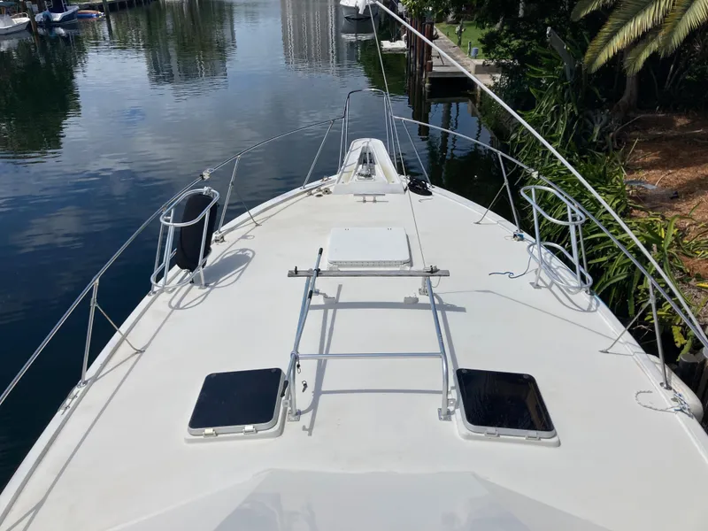 Slide: The Image of 1976 Hatteras 46 yacht deck with railing, docked by a calm waterway. - 5