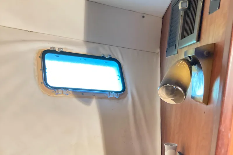 Slide: The Image of Interior of 1976 Hatteras 46 yacht with porthole and wall-mounted light. - 52