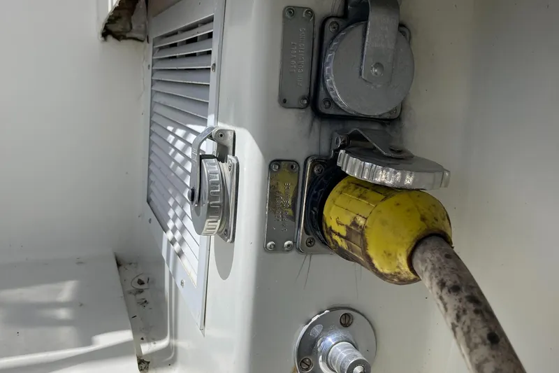 Slide: The Image of 1976 Hatteras 46 boat electrical panel with yellow power cable connection. - 55
