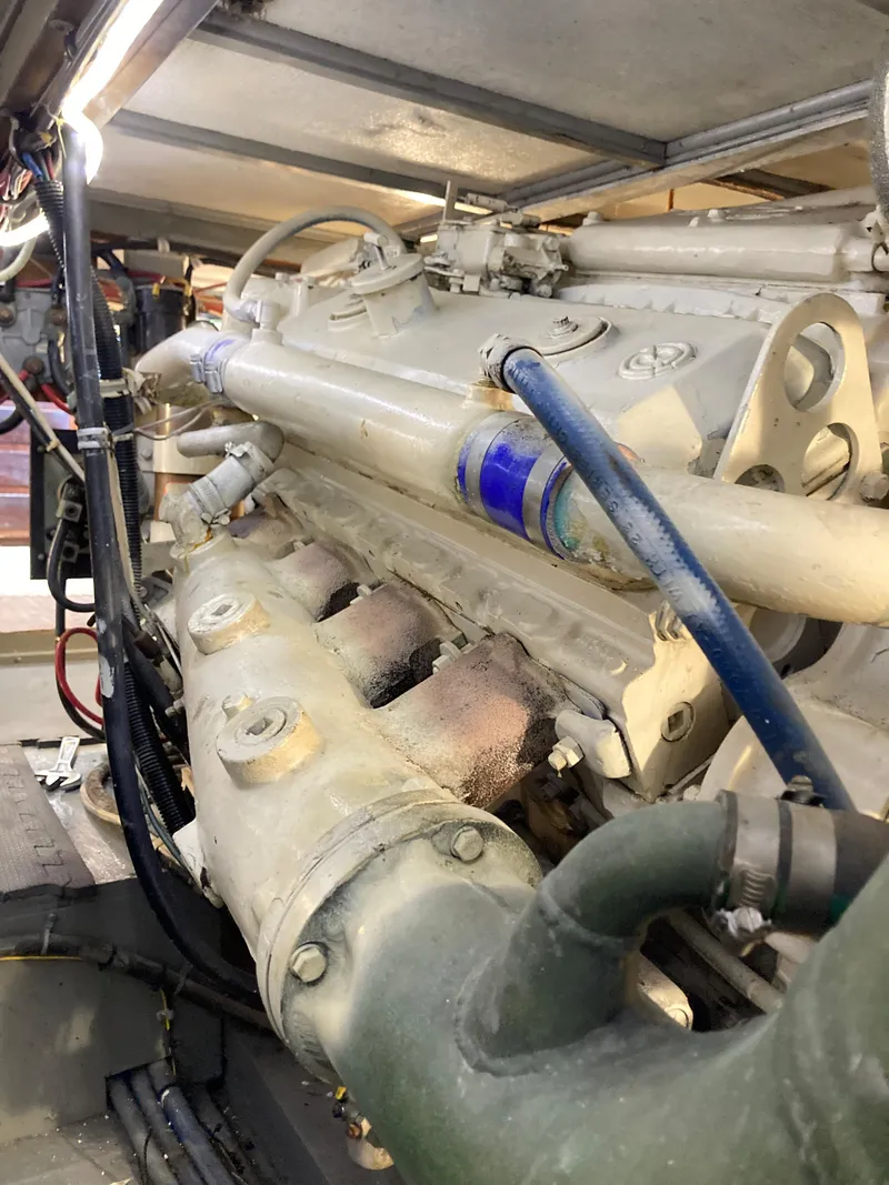 Slide: The Image of Engine compartment of a 1976 Hatteras 46 yacht, showcasing mechanical components. - 57