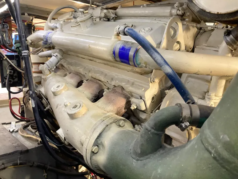 Slide: The Image of Engine of a 1976 Hatteras 46 yacht, showcasing mechanical components and hoses. - 58
