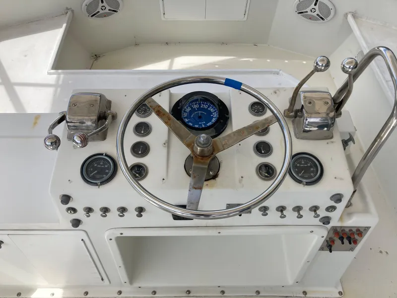 Slide: The Image of 1976 Hatteras 46 boat helm with steering wheel and control panel. - 6