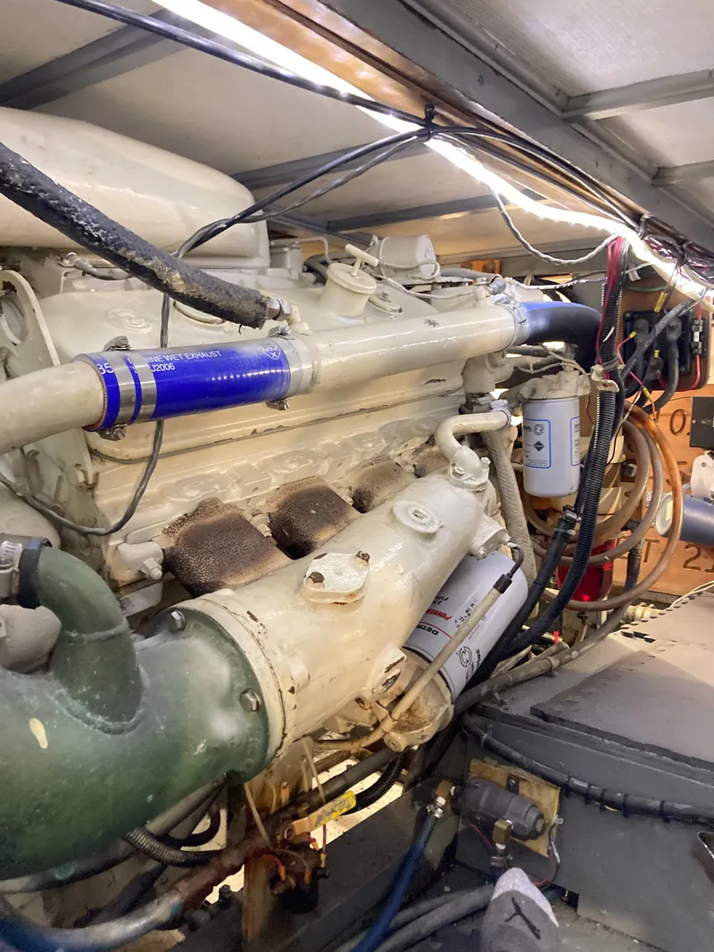 Slide: The Image of Engine room of a 1976 Hatteras 46 yacht, showcasing mechanical components and wiring. - 61