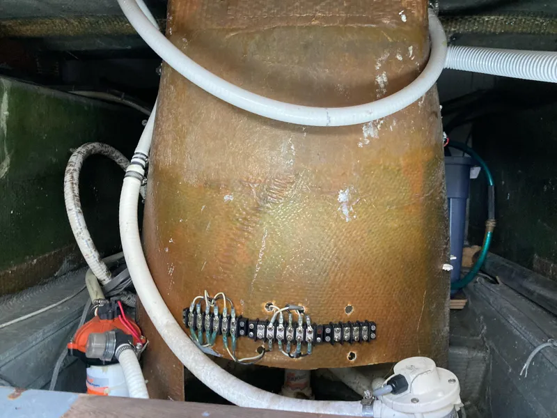 Slide: The Image of 1976 Hatteras 46 engine room with wiring and hoses. - 66