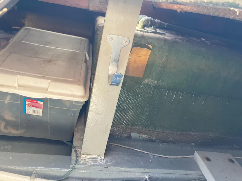 Slide: The Image of Storage compartment in a 1976 Hatteras 46 boat with plastic container and equipment. - 70