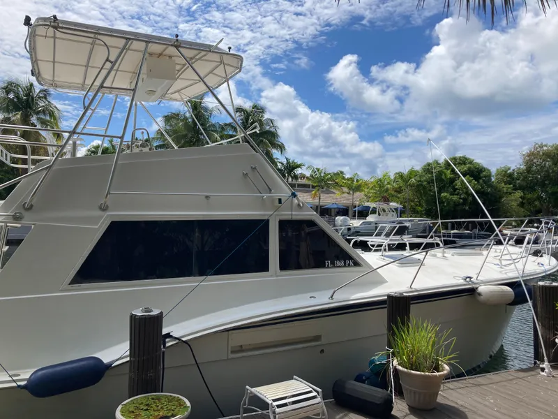 Slide: The Image of 1976 Hatteras 46 yacht docked under a partly cloudy sky. - 8