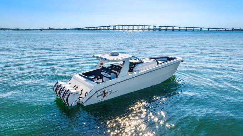 Slide: The Image of 2023 Cigarette 42 Auroris boat on calm water with bridge in background. - 5