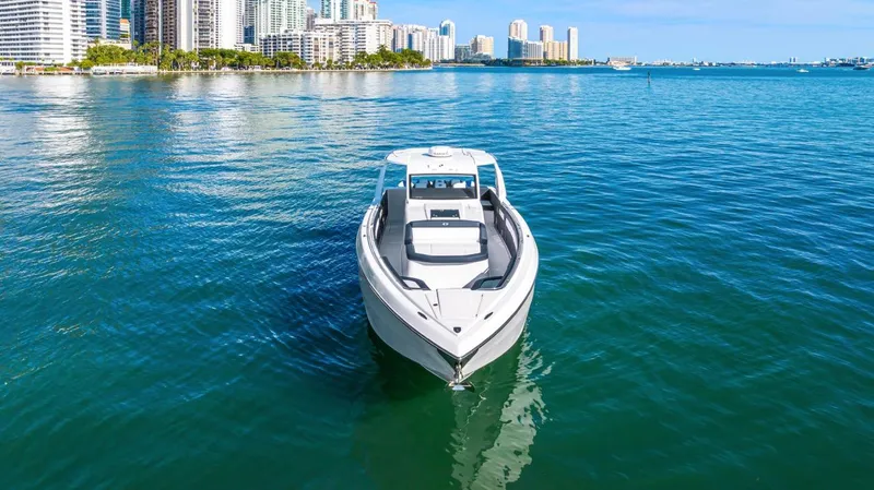 Slide: The Image of 2023 Cigarette 42 Auroris boat on clear blue water with city skyline background. - 6