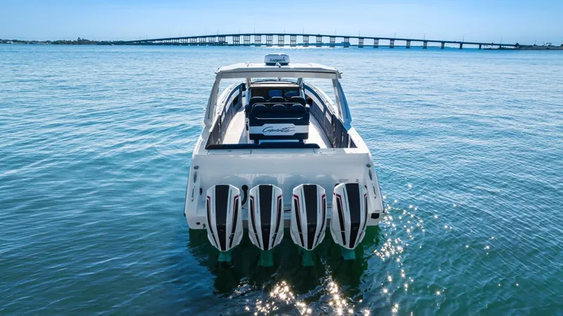 Slide: The Image of 2023 Cigarette 42 Auroris boat with four engines on calm water, bridge in background. - 7