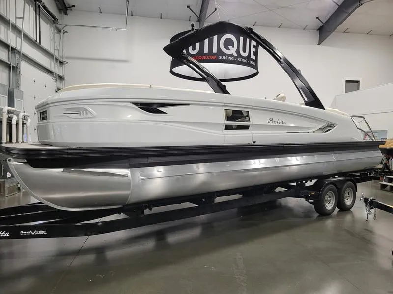 Slide: The Image of 2024 Barletta LEGGERA R26UCA pontoon boat on trailer in showroom. - 18