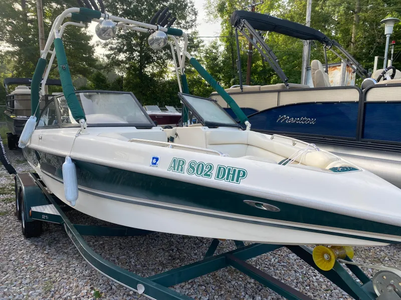 Slide: The Image of 2001 Tigé 211 boat on trailer, parked outdoors with other boats. - 1