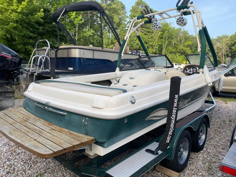 Slide: The Image of 2001 Tigé 211 boat on trailer, parked outdoors, with wakeboard tower and speakers. - 3