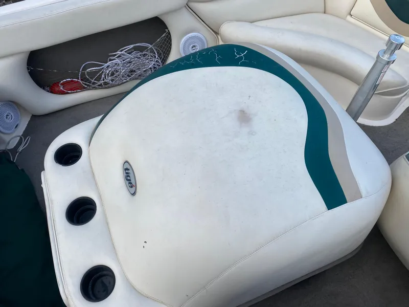 Slide: The Image of 2001 Tigé 211 boat interior with white and teal seating, cup holders, and storage compartment. - 5