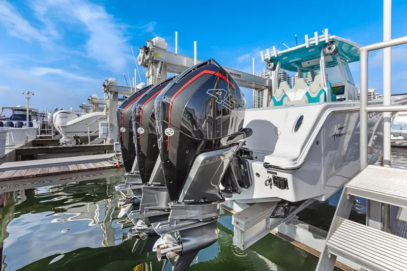 Slide: The Image of 2025 Streamline 35 CC boat with triple outboard engines docked at marina. - 18