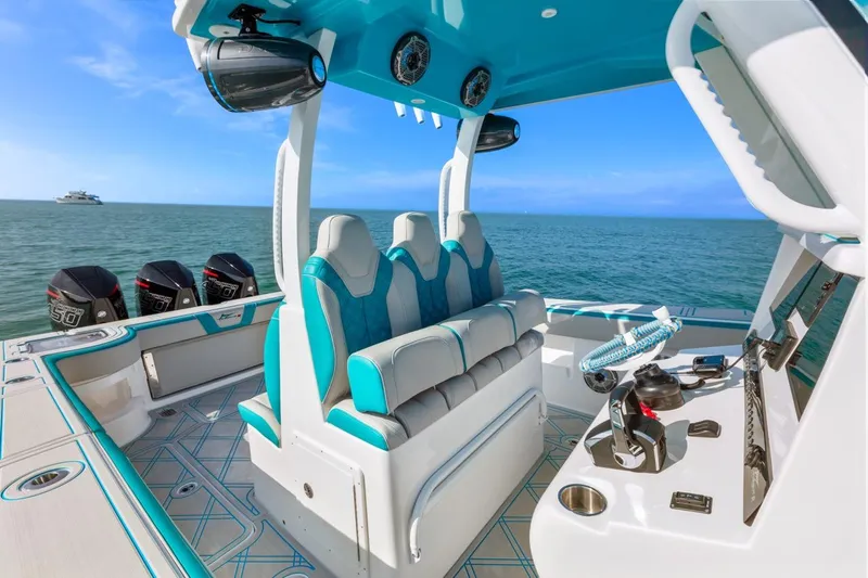 Slide: The Image of 2025 Streamline 35 CC boat interior with turquoise seating and advanced controls on open water. - 24