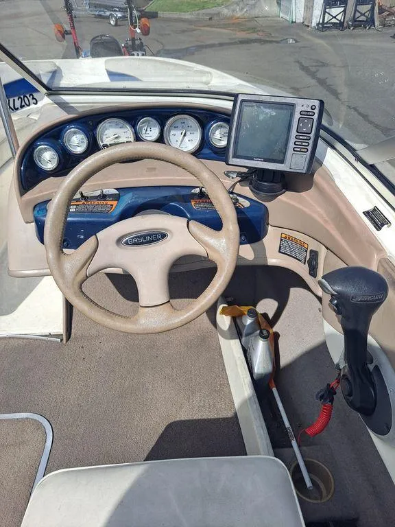 Slide: The Image of 2003 Bayliner 205 Olympic Edition boat dashboard with steering wheel and navigation system. - 12
