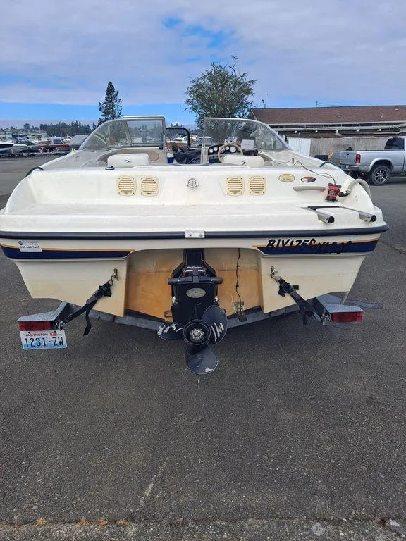 Slide: The Image of 2003 Bayliner 205 Olympic Edition boat, rear view, parked on asphalt. - 14