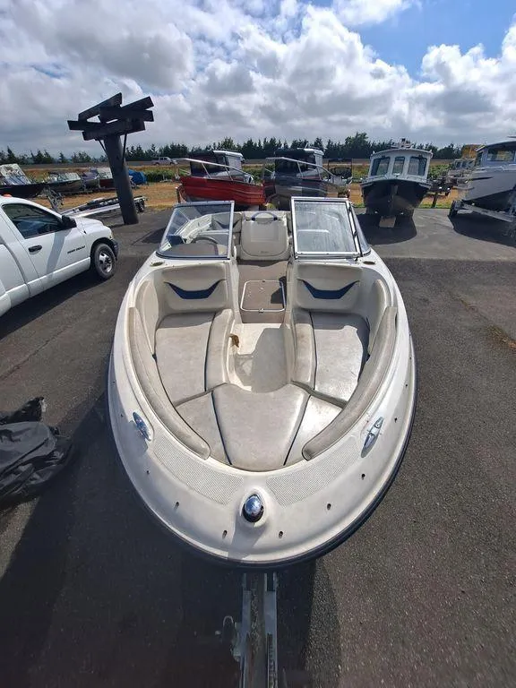 Slide: The Image of 2003 Bayliner 205 Olympic Edition boat on display in a marina. - 7