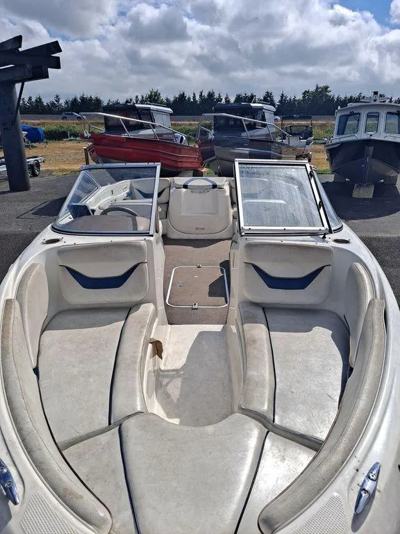 Slide: The Image of 2003 Bayliner 205 Olympic Edition boat with open bow seating, parked outdoors. - 9