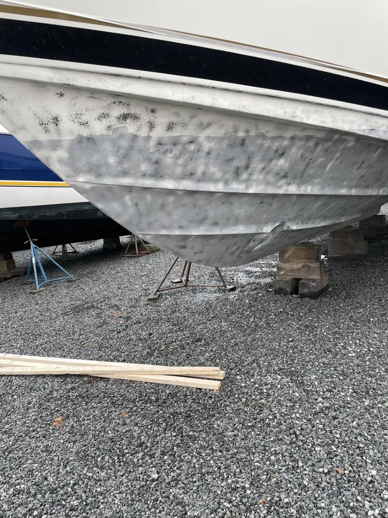 Slide: The Image of 1993 Tiara Yachts Convertible 43 hull on gravel, showing wear and tear. - 23