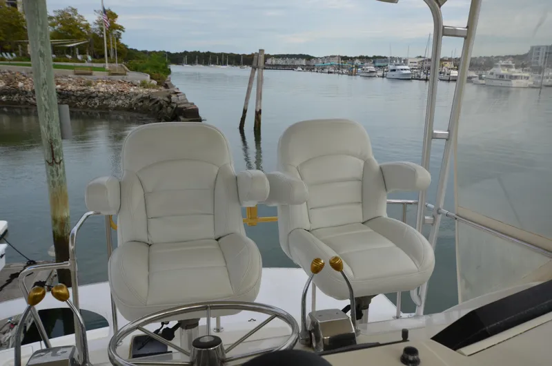 Slide: The Image of Two white captain chairs on 1993 Tiara Yachts Convertible 430, overlooking marina. - 7