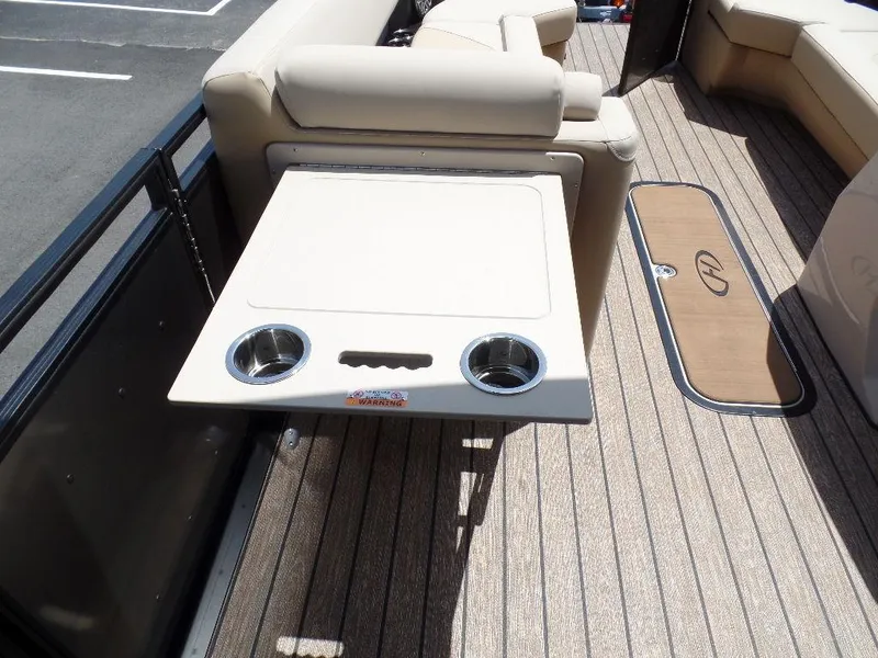 Slide: The Image of 2025 Harris Solstice 270 REC boat interior with beige seating and table. - 10