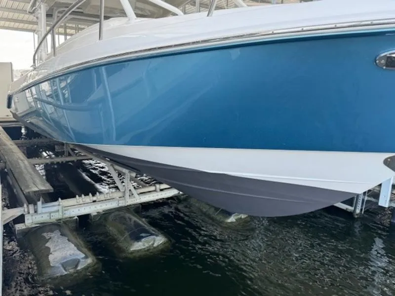 Slide: The Image of 2016 Everglades 360LXC boat on lift, blue hull, docked in marina. - 12