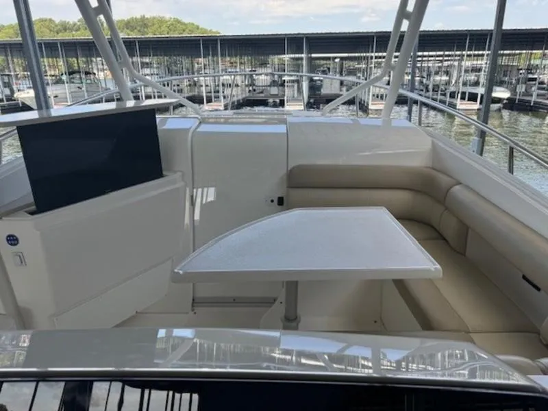 Slide: The Image of 2016 Everglades 360LXC boat interior with seating and table, docked at marina. - 16
