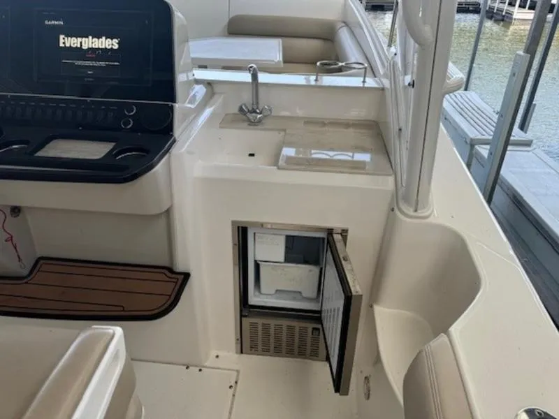 Slide: The Image of 2016 Everglades 360LXC boat interior with open mini fridge and sink. - 18