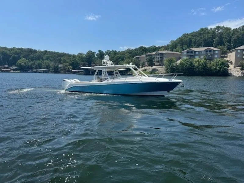 Slide: The Image of 2016 Everglades 360LXC boat cruising on a scenic lake. - 2