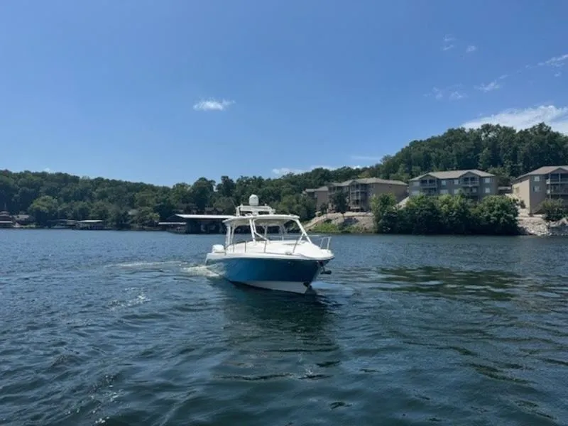 Slide: The Image of 2016 Everglades 360LXC boat cruising on a scenic lake. - 21