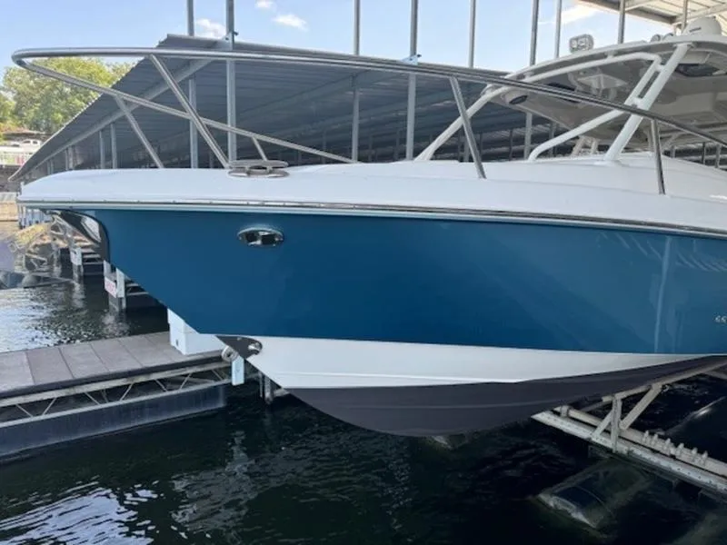 Slide: The Image of 2016 Everglades 360LXC boat docked in marina, blue and white hull. - 22
