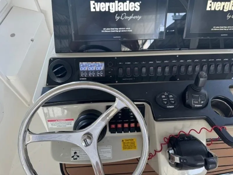 Slide: The Image of Control panel of 2016 Everglades 360LXC boat with steering wheel and electronic displays. - 25