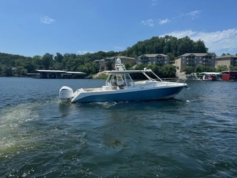 Slide: The Image of 2016 Everglades 360LXC boat on a scenic lake with waterfront homes. - 30