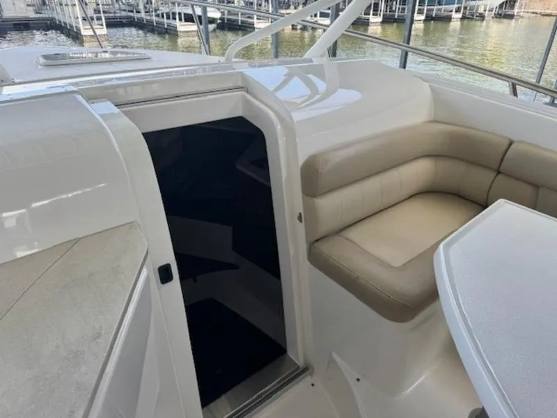 Slide: The Image of 2016 Everglades 360LXC boat interior with beige seating and table. - 33