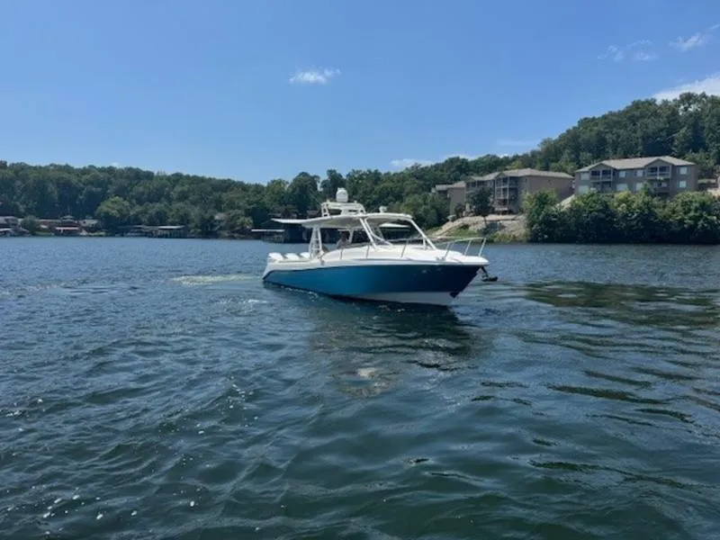 Slide: The Image of 2016 Everglades 360LXC boat on a lake with scenic shoreline background. - 34