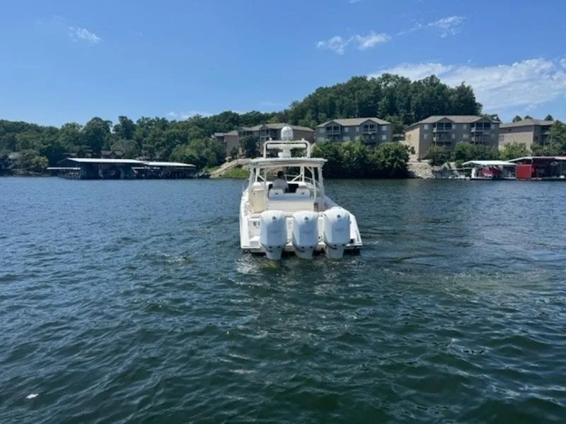 Slide: The Image of Everglades 360LXC 2016 boat on a lake with scenic shoreline and buildings. - 38