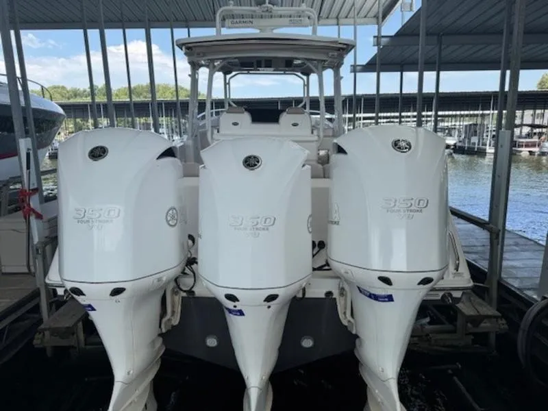 Slide: The Image of 2016 Everglades 360LXC boat with triple outboard engines docked in a marina. - 4