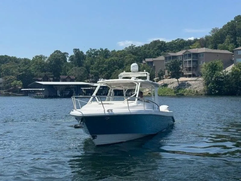 Slide: The Image of 2016 Everglades 360LXC boat on a scenic lake with trees and buildings. - 45