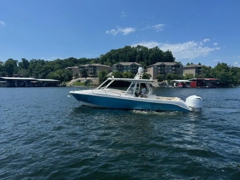 Slide: The Image of 2016 Everglades 360LXC boat cruising on a lake under a clear blue sky. - 46