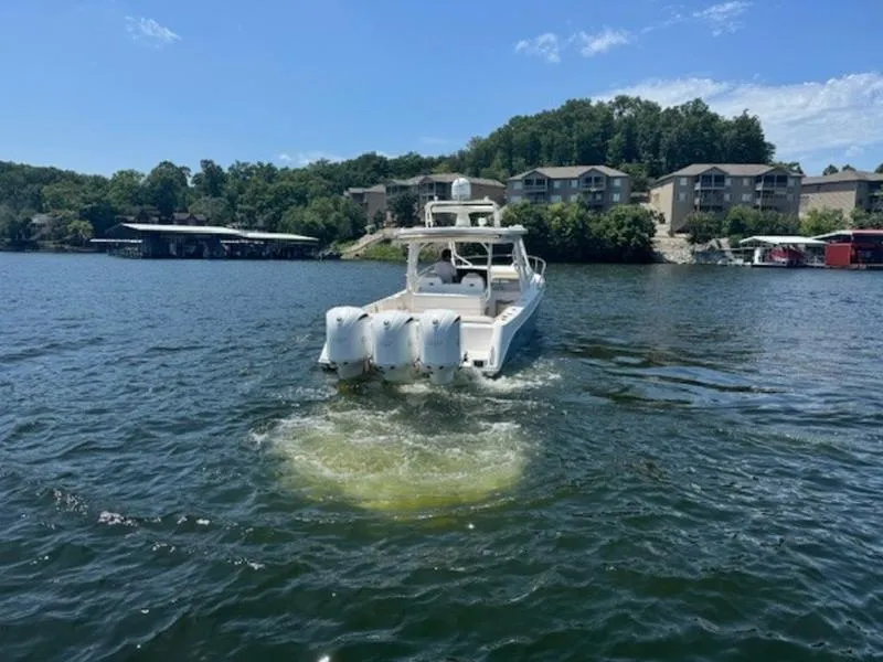 Slide: The Image of 2016 Everglades 360LXC boat cruising on a scenic lake. - 48