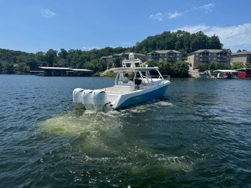 Slide: The Image of 2016 Everglades 360LXC boat cruising on a lake with scenic shoreline. - 6